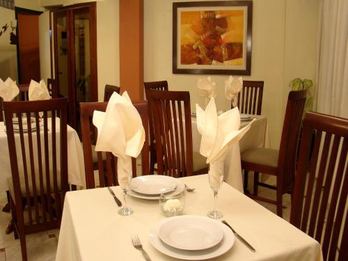 a table with white plates and napkins on it at Hotel Torre Norte in Trujillo