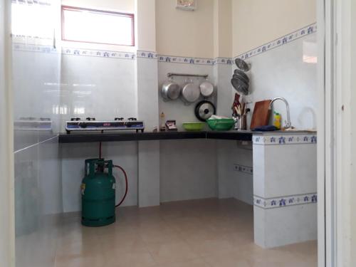 a kitchen with a green water hydrant in a room at Ngoc Sang Guesthouse in Mui Ne