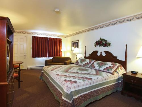 Habitación de hotel con cama y silla en Amish Country Motel, en Bird-in-Hand