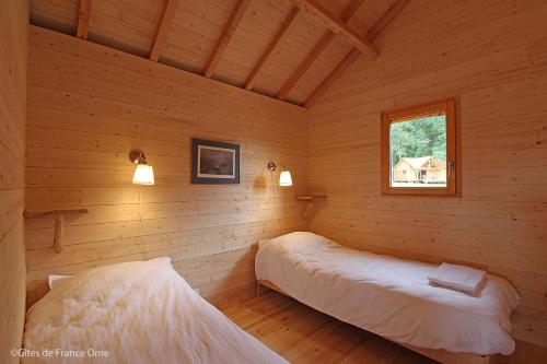 a bedroom with two beds in a log cabin at Country Lodge in Les Épasses