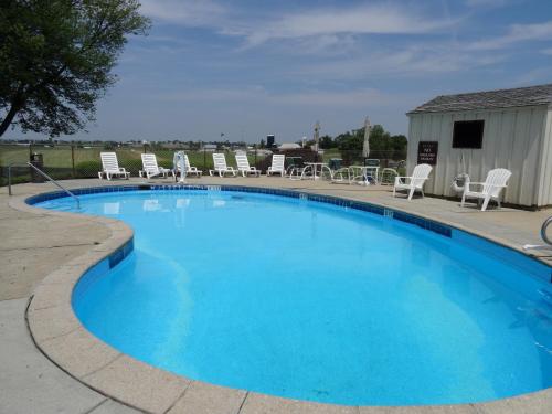 une grande piscine bleue entourée de chaises dans l'établissement Amish Country Motel, à Bird-in-Hand