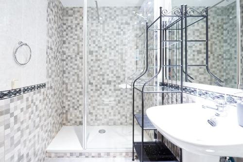 ein Bad mit einer Dusche, einem Waschbecken und einem WC in der Unterkunft Royal Palace Boutique in Madrid