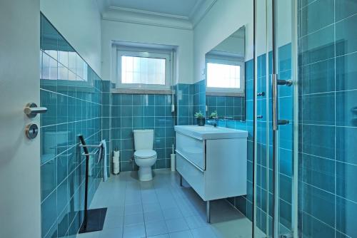 a blue bathroom with a sink and a toilet at Liverpool Terrace in Lisbon