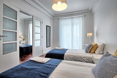 a bedroom with two beds and a window at Liverpool Terrace in Lisbon