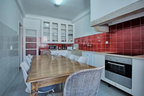 a kitchen with a wooden table and red tiles at Liverpool Terrace in Lisbon