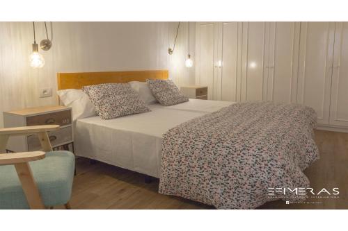 Un dormitorio con una cama con colcha blanca y almohadas. en Apartamento Atlántico Playa 1, en Puerto Naos