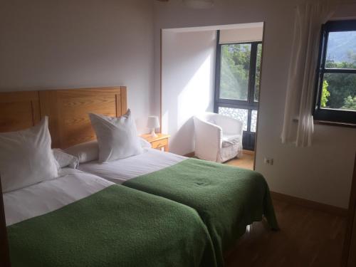 1 dormitorio con 1 cama grande con manta verde en Apartamentos Casa de la Abuela, en Potes