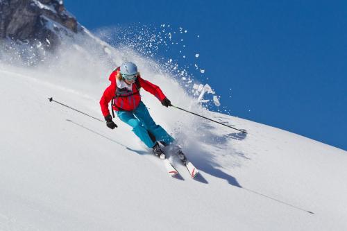 a man is skiing down a snow covered slope at Lebensquelle Krapfenhof in Finkenberg