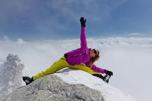 a woman sitting on top of a rock with her hand in the air at Lebensquelle Krapfenhof in Finkenberg