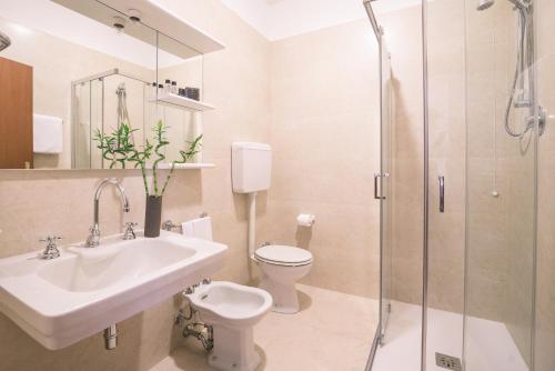 a bathroom with a sink and a toilet and a shower at Hotel Europa in Ferrara