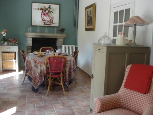 ein Esszimmer mit einem Tisch, Stühlen und einem Kamin in der Unterkunft Maison d'Hôtes Augès in Tréguier