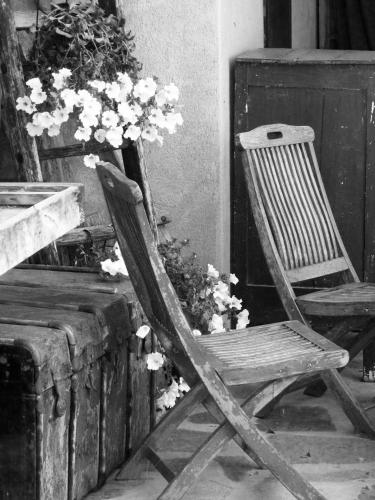 a wooden chair sitting next to a table with flowers at B&B Cascina Marie in Bricherasio