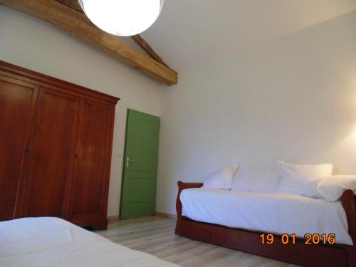a bedroom with two beds and a green door at Gite Le Clos Constance in Charrais