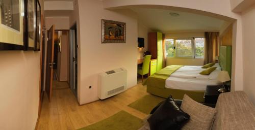 ベオグラードにあるベッド＆ブレックファースト ガーデン40のベッドとソファ付きのホテルルーム
