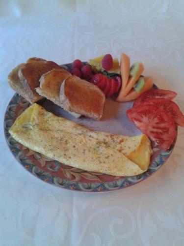 a plate of food with bread and fruit on it at Au Soleil Couchant in Val-dʼOr