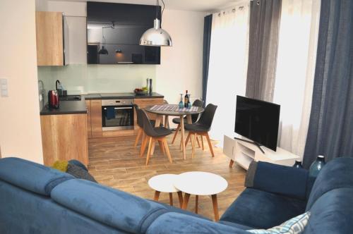 salon z niebieską kanapą i kuchnią w obiekcie Windrose Apartment w Świnoujściu
