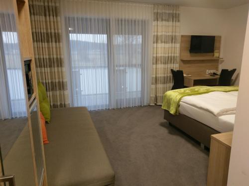a hotel room with a bed and a television at Gasthaus Pension Rezatgrund in Windsbach