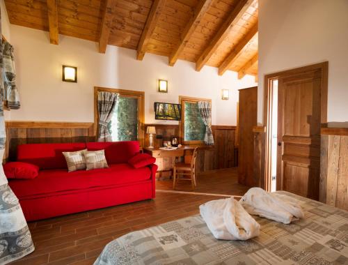 a living room with a red couch and a table at Drésalwoald in Gressoney-Saint-Jean