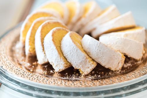 a plate filled with slices of bread with powdered sugar at Hotel Europa in Ferrara