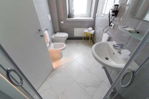 a white bathroom with a sink and a toilet at Altavilla Boutique Hotel in Catanzaro
