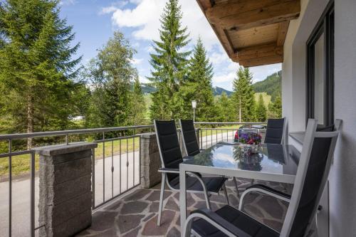 eine Terrasse mit einem Tisch und Stühlen auf dem Balkon in der Unterkunft Appart Gitti in Gerlos