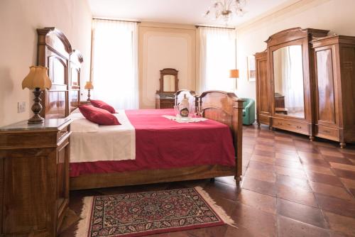 a bedroom with a large bed with a red blanket at Hotel Europa in Ferrara