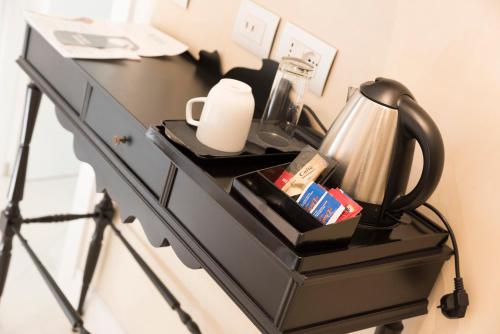 a black dresser with a tea kettle on it at Altavilla Boutique Hotel in Catanzaro