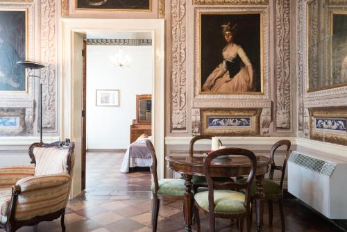 a dining room with a table and chairs and a painting at Hotel Europa in Ferrara