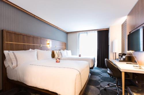 a hotel room with two beds and a desk at Crowne Plaza HY36 Midtown Manhattan by IHG in New York