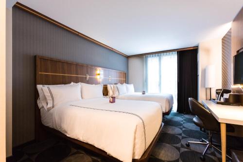 a hotel room with two beds and a desk at Crowne Plaza HY36 Midtown Manhattan by IHG in New York