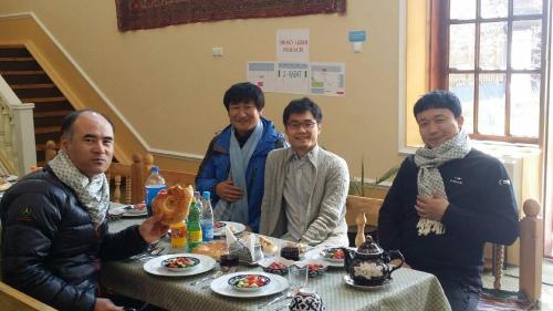 a group of men sitting around a table with food at Guest House Ikathouse in Margilan