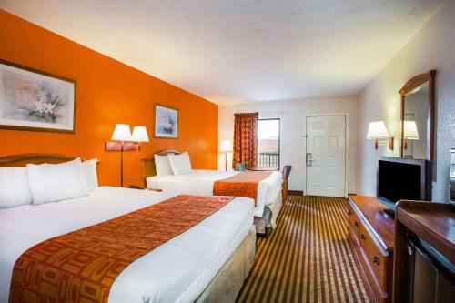 a hotel room with two beds and a flat screen tv at Howard Johnson by Wyndham Panama City in Panama City