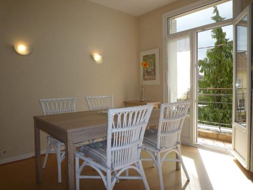 d'une salle à manger avec une table, des chaises et une fenêtre. dans l'établissement Appartement Hello, à Metz