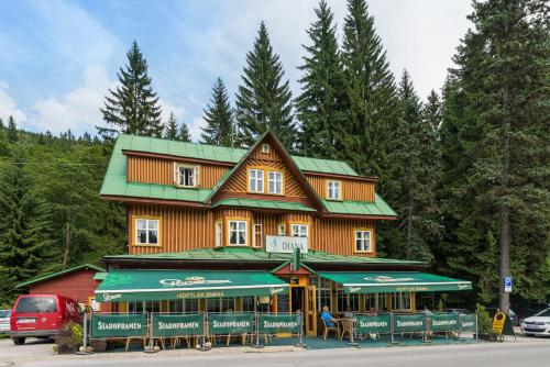 a large wooden building with a green roof at Hotel Diana in Špindlerův Mlýn
