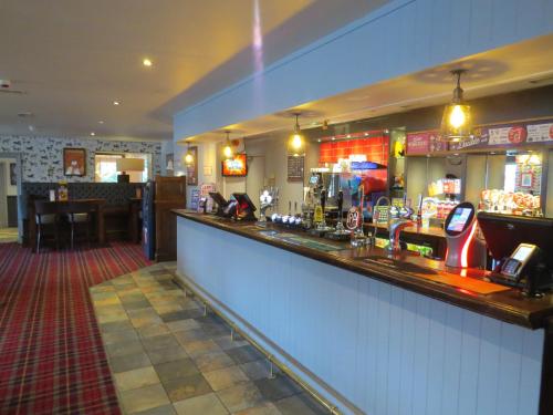 a bar in a pub with a counter and a bar sidx sidx at Highwayman Hotel in Dunstable