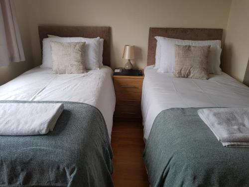 two beds sitting next to each other in a bedroom at Kathleen House in Enfield