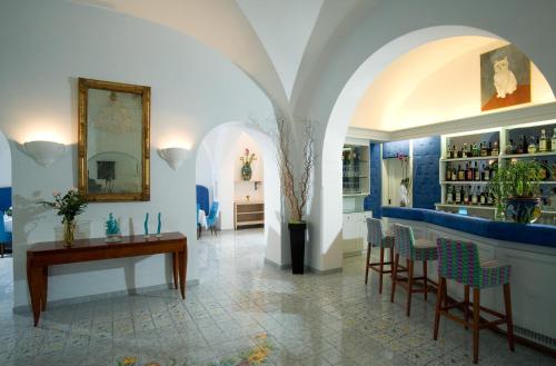 a room with a bar with a table and chairs at Albergo Gatto Bianco in Capri