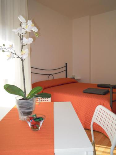 a table with a plant on top of a bed at Like Home Cisanello in Pisa
