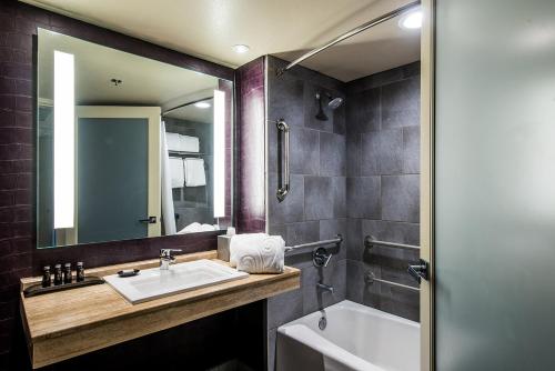 a bathroom with a sink and a mirror and a tub at Hotel Zoso in Palm Springs