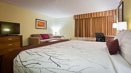 a hotel room with a large bed and a couch at White Pine Inn & Suites in Holland