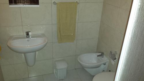 a white bathroom with a sink and a toilet at Hospedaria D. Fernando in Viseu