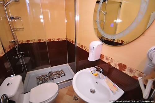 a bathroom with a toilet and a sink and a mirror at Black Sea Star Batumi in Batumi