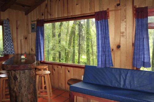 a room with a large window in a cabin at Cabañas Alpinas López Fontes in Valle de Bravo
