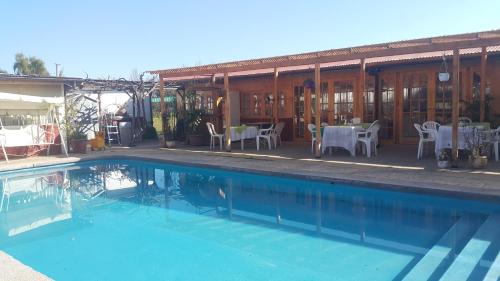 - une piscine en face d'un bâtiment avec des tables et des chaises dans l'établissement Casa Blanca Rinconada de Silva, à Putaendo