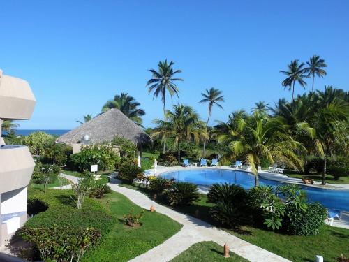an aerial view of a resort with a swimming pool and palm trees at Luxury apartment with ocean view at the beach in Cabarete