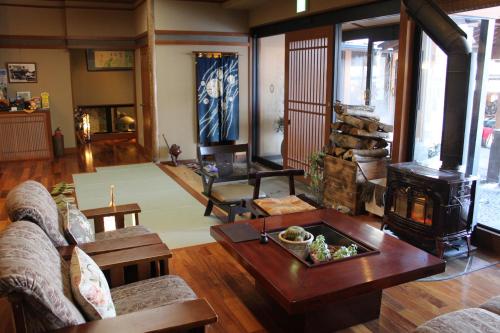 a living room with a couch and a wood stove at Hanaichi in Tsumagoi