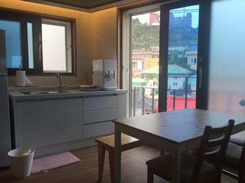 a kitchen with a table and a kitchen with a window at Guest House Dalggume in Mokpo
