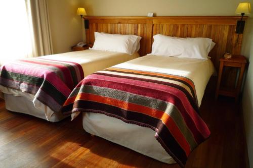 two beds sitting next to each other in a room at Hosteria Senderos in El Chalten