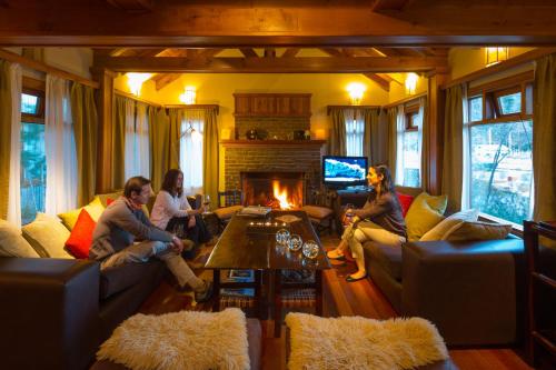 a group of people sitting in a living room with a fireplace at Hosteria Senderos in El Chalten