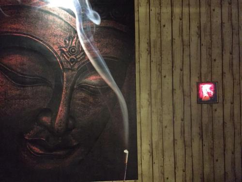 un mur orné d'un tableau représentant une femme avec un sifflet à fumée dans l'établissement Shannu's Ranch Inn, à Pushkar